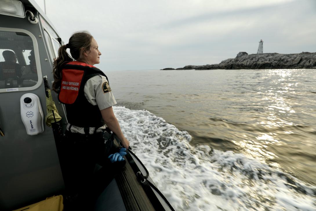 Canada DFO Officer on patrol with lighthouse in background
